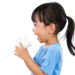 child speaking into paper cup