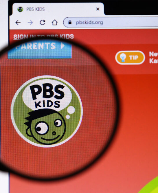 Image of magnifying glass over PRS logo, to find out what is the controversy with Caillou.