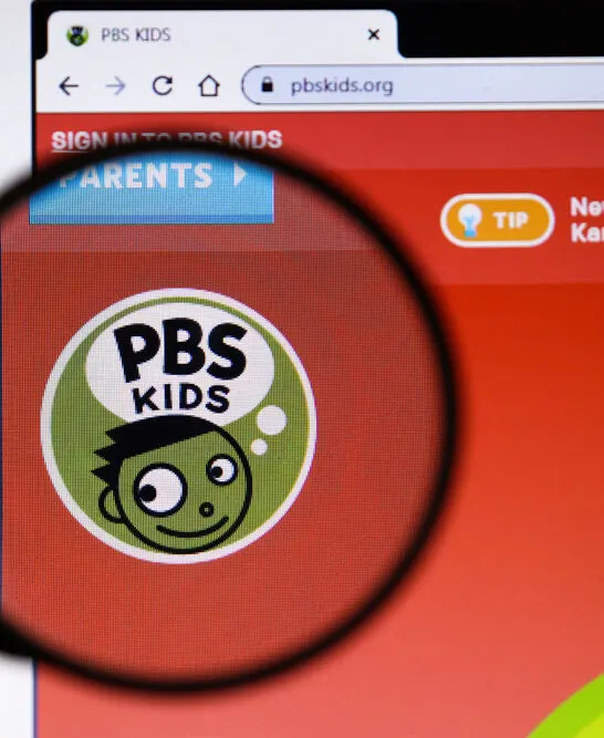 Image of magnifying glass over PRS logo, to find out what is the controversy with Caillou.
